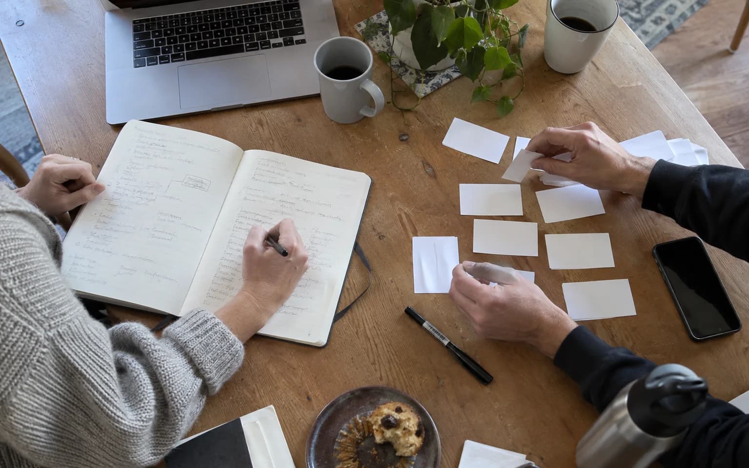 Photo générée par IA : des notes de réunion, un ordinateur et des cartes sont disposés sur une table.