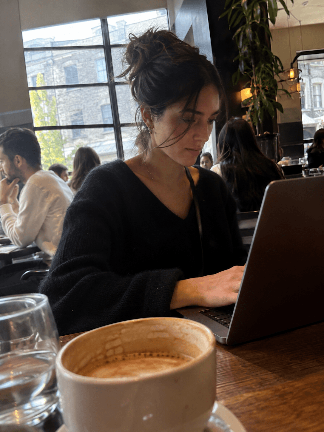 Illustration générée par IA : une personne utilise un ordinateur portable dans un café.